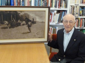 Ralph H. Baer poses in Norman Rockwell Museum's Archives in September 2011, with a painting of another pioneer: Daniel Boone. Mr Baer is considered the "father of video games," and donated the original painting to the Museum back in the 1990s. Photo courtesy Ralph H. Baer. All rights reserved.